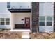 Inviting two-story home with a red front door, stone accents, and a covered entryway at 1070 Splash Shot Pl, Davenport, FL 33896