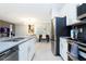 Bright kitchen showcasing stainless appliances, white cabinets, gray countertops, and open to dining area at 1070 Splash Shot Pl, Davenport, FL 33896