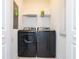 Functional laundry room with modern black washer and dryer; overhead storage space available at 1070 Splash Shot Pl, Davenport, FL 33896