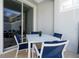 The patio features a modern table with four chairs with seating for outdoor dining at 1070 Splash Shot Pl, Davenport, FL 33896