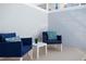 Outdoor sitting area with matching blue patio chairs, a white table, and pillows on a neutral patio at 1070 Splash Shot Pl, Davenport, FL 33896
