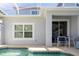 Covered patio with view of pool has seating for four and sliding glass door access to interior at 1070 Splash Shot Pl, Davenport, FL 33896