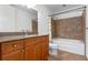 Bathroom boasts a single sink vanity with granite counters, a commode, and a bathtub with a tile surround at 150 E Robinson St # 1023, Orlando, FL 32801