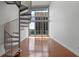 Spacious living room featuring a modern spiral staircase, gleaming hardwood floors, and a large window with city views at 150 E Robinson St # 1023, Orlando, FL 32801