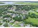 An aerial view of a neighborhood with lush greenery, a lake and a mix of homes, many featuring private pools at 1536 Pine Island Rd, Kissimmee, FL 34744