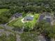 Aerial view of a well maintained property with a beautiful pool surrounded by lush landscaping and mature trees at 1536 Pine Island Rd, Kissimmee, FL 34744