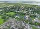 An aerial view of a green community with numerous homes, many with pools, nestled amongst mature trees at 1536 Pine Island Rd, Kissimmee, FL 34744