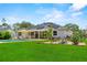 Expansive backyard featuring a pool, solar panels, lush green lawn, patio seating and landscaped areas at 1536 Pine Island Rd, Kissimmee, FL 34744