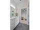 Bright bathroom featuring double vanity, grey tile floors, and doorway to bedroom at 1536 Pine Island Rd, Kissimmee, FL 34744