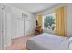 Comfortable bedroom with hardwood floors, a large closet and a window with yellow curtains at 1536 Pine Island Rd, Kissimmee, FL 34744