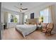 Serene bedroom with a wood bed frame, neutral colors, and abundant natural light from the surrounding windows at 1536 Pine Island Rd, Kissimmee, FL 34744