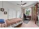Bright bedroom featuring a ceiling fan, large window, closet, and home office area at 1536 Pine Island Rd, Kissimmee, FL 34744