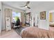 Bedroom with hardwood floors, large window, ceiling fan, and adjacent ensuite bath at 1536 Pine Island Rd, Kissimmee, FL 34744