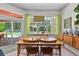 Bright dining room view to pool area featuring wood floors, light green curtains, and a modern lighting fixture at 1536 Pine Island Rd, Kissimmee, FL 34744