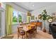 Bright dining room featuring wood floors, light green curtains, and modern lighting fixture above the table at 1536 Pine Island Rd, Kissimmee, FL 34744