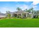 Beautifully landscaped one story home with a sprawling green lawn and mature trees on a sunny day at 1536 Pine Island Rd, Kissimmee, FL 34744