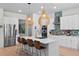Bright, modern kitchen with a large center island, pendant lighting, stainless steel appliances and white cabinets at 1536 Pine Island Rd, Kissimmee, FL 34744