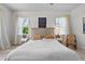 Bright main bedroom featuring wood floors, two windows, minimalist décor and a white cotton quilt at 1536 Pine Island Rd, Kissimmee, FL 34744