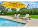 Inviting backyard pool with lounge chairs and a yellow umbrella, perfect for relaxation and enjoying the outdoors at 1536 Pine Island Rd, Kissimmee, FL 34744