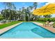 Backyard swimming pool with a yellow umbrella and lounge chairs on the pool deck at 1536 Pine Island Rd, Kissimmee, FL 34744