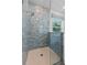 Elegant walk-in shower featuring a glass door, modern fixtures and blue tiling at 1536 Pine Island Rd, Kissimmee, FL 34744