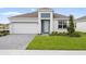 Charming single-Gathering home features a two-car garage, manicured lawn, and neutral-colored exterior at 1568 Gardiner St, Haines City, FL 33844