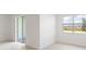 An open-concept space with neutral walls, tile flooring, a sliding glass door, and a window with backyard views at 1568 Gardiner St, Haines City, FL 33844