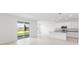 Open-concept living space boasts bright white walls, tile flooring, and sliding glass doors to the backyard at 1568 Gardiner St, Haines City, FL 33844