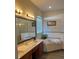 Bright bathroom featuring double sinks, an enclosed shower, and a garden tub at 160 Calabay Parc Blvd, Davenport, FL 33897