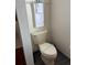 A clean, standard toilet with a towel hanging above it, near a partial cabinet at 160 Calabay Parc Blvd, Davenport, FL 33897