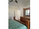 Cozy bedroom featuring a wooden dresser, full size mirror, and green patterned comforter at 160 Calabay Parc Blvd, Davenport, FL 33897