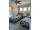 Cozy bedroom featuring two twin beds, natural light from windows, and wood-look floors at 160 Calabay Parc Blvd, Davenport, FL 33897