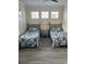 Bright bedroom with two twin beds, floral bedding, and a shared nightstand under bright windows at 160 Calabay Parc Blvd, Davenport, FL 33897