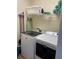Well-equipped laundry room with a modern washer and dryer, storage shelves, and essential cleaning supplies at 160 Calabay Parc Blvd, Davenport, FL 33897