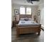 A bedroom with a wood framed bed, bedside tables, and side windows at 160 Calabay Parc Blvd, Davenport, FL 33897