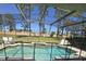 The screened in pool area features ample lounging space and a peaceful backyard view at 160 Calabay Parc Blvd, Davenport, FL 33897