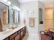 Well-lit bathroom featuring double vanity with modern fixtures and stylish mirrors and a tiled shower at 169 Verde Way, Debary, FL 32713