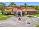 Aerial view of the community clubhouse featuring beautiful landscaping, a fountain, and ample parking for residents at 169 Verde Way, Debary, FL 32713