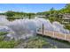 Scenic waterfront view featuring a private dock, surrounded by lush greenery under a bright blue sky at 169 Verde Way, Debary, FL 32713