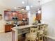 Kitchen featuring breakfast bar, wood cabinets, granite countertops, and stainless steel appliances at 169 Verde Way, Debary, FL 32713