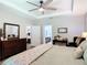 Well-lit bedroom features a ceiling fan, tray ceiling, and ensuite bathroom access at 169 Verde Way, Debary, FL 32713