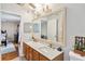 Bright bathroom featuring double sinks with marble countertops and an oversized mirror at 176 Hidden View Dr, Groveland, FL 34736