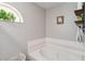 Relaxing bathroom showcasing an inviting soaking tub and an arched window providing natural light at 176 Hidden View Dr, Groveland, FL 34736