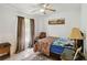 Comfortable bedroom with ceiling fan, natural light from window, and antique desk with lamp at 176 Hidden View Dr, Groveland, FL 34736