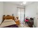 Bright bedroom with ceiling fan, light walls, patterned curtains, and a cozy workstation at 176 Hidden View Dr, Groveland, FL 34736