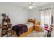 Cozy bedroom with ceiling fan, light walls, patterned curtains, and a comfortable twin bed at 176 Hidden View Dr, Groveland, FL 34736