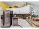 Kitchen with stainless steel refrigerator and dishwasher, granite countertops, and mosaic tile backsplash at 176 Hidden View Dr, Groveland, FL 34736