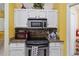 Kitchen featuring stainless steel range and microwave, granite countertops, and white cabinets at 176 Hidden View Dr, Groveland, FL 34736