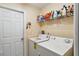 A functional laundry room with a washer, dryer, storage shelf and door at 176 Hidden View Dr, Groveland, FL 34736
