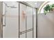 Shower featuring tiled walls, shower head, handheld sprayer, and a frosted glass sliding door at 176 Hidden View Dr, Groveland, FL 34736